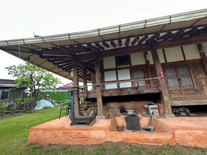 un edificio con tenda da sole e griglia in un cortile di Big Blue House a Boseong