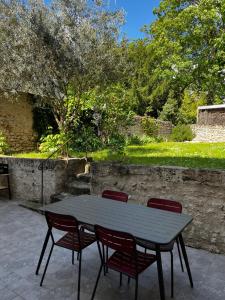 einen Tisch und vier Stühle neben einer Steinmauer in der Unterkunft Maison Centre ville Blois in Blois