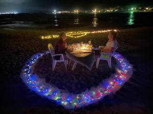 dwoje ludzi siedzących przy stole w kształcie serca w obiekcie Seginy Seaview w mieście Guraidhoo
