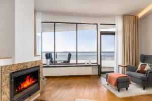 a living room with a fireplace and a view of the ocean at BlydeHomes - Amazing Seaview! in Tallinn