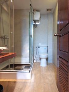 a bathroom with a toilet and a glass shower at Nary Apartment in Siem Reap