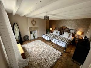 a living room with two beds and a fireplace at Coupling Cottage in Belper