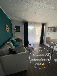 Sala de estar con cama y mesa en Studio Le Pharo Résidence avec piscine, en Cap d'Agde