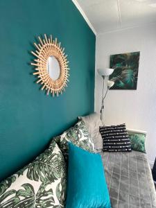 1 dormitorio con pared azul y espejo en Studio Le Pharo Résidence avec piscine, en Cap d'Agde