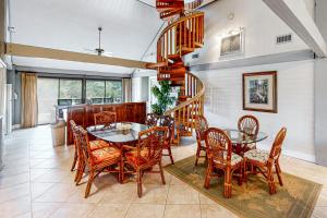 a dining room with a table and chairs and a spiral staircase at Knot Too Shabby in St. George Island
