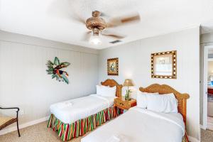 a bedroom with two beds and a ceiling fan at Knot Too Shabby in St. George Island