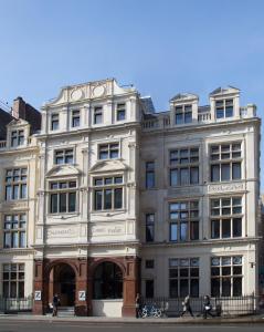 un gran edificio blanco con gente caminando delante de él en The Z Hotel Shoreditch, en Londres