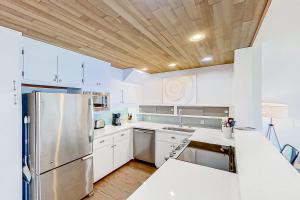 a kitchen with white cabinets and a stainless steel refrigerator at Lake Chelan Shores Picture Perfect 11 to 6 in Chelan