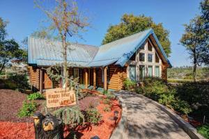 a log home with a sign in front of it at The Happy Bear Lodge in Shasta Lake