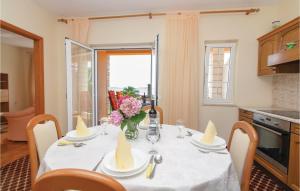 einen Esstisch mit einem weißen Tischtuch und Blumen in der Unterkunft Beautiful Apartment In Orebic With 2 Bedrooms And Wifi in Orebić