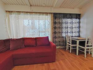 ein Wohnzimmer mit einem roten Sofa und einem Tisch in der Unterkunft ART Hotel JUNA in Imatra