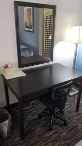 a desk with a mirror and a chair in a room at OSU 2 Queen Beds Hotel Room Wi-Fi 106 Hot Tub Booking in Stillwater