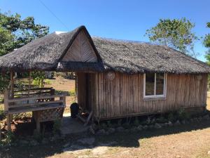 a small hut with a thatched roof and a bench at SEE-KEE-HOR Cafe and Hostel in Siquijor