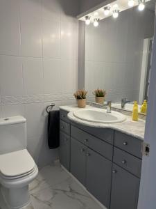 łazienka z umywalką, toaletą i lustrem w obiekcie Bonito apartamento w Marbelli