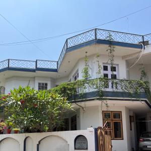 a white house with a balcony on top of it at Travel curiosity Homestay in Alwar