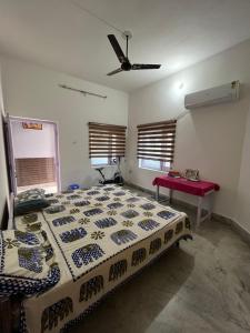 a bedroom with a bed and a ceiling fan at Travel curiosity Homestay in Alwar