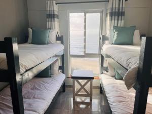 two bunk beds in a room with a window at Santana 804 Beachfront Apartment with spectacular sea views in Margate