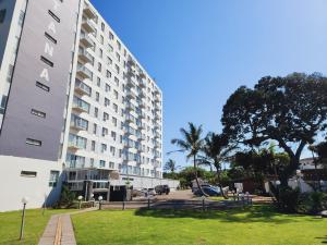 a large white building with a park next to it at Santana 804 Beachfront Apartment with spectacular sea views in Margate