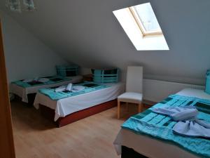 a attic room with two beds and a window at Hotel Garni zum Goldenen Ring in Quedlinburg