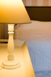 コンピエーニュにあるLequatorzeのベッド横のテーブルに座る白いランプ
