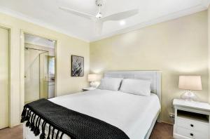 sypialnia z białym łóżkiem i wentylatorem sufitowym w obiekcie Maple Rose Bowral w mieście Bowral