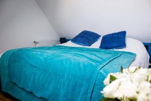 a bedroom with a blue bed with blue pillows at Lequatorze in Compiègne