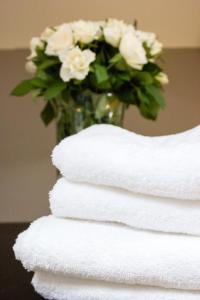 a stack of towels with a vase filled with flowers at Lequatorze in Compiègne