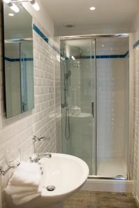 a bathroom with a sink and a glass shower at Lequatorze in Compiègne