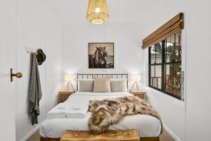 a bedroom with a bed with a furry blanket on it at Bryony Cottage Berrima in Berrima