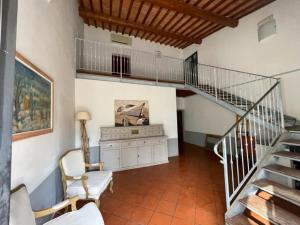 uma sala de estar com uma escada e uma mesa e cadeiras em La Fattoria di Rendola em Montevarchi
