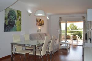 a dining room with a glass table and white chairs at CASA RIERA in Les tres Cales