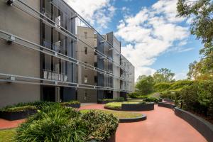 un edificio de apartamentos con un patio con plantas en Mantra Castle Hill Sydney, an Accor Hotel, en Castle Hill