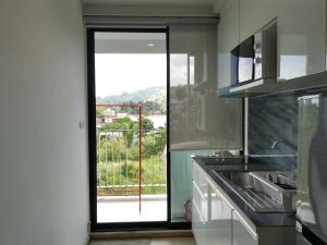 una cocina con una puerta corredera de cristal que da a un balcón en 4 Floor - Centrio Condominium in Phuket town en Phuket