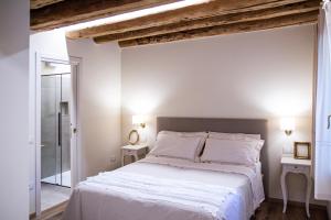 um quarto com uma grande cama branca com vigas expostas em Alloggi I Calieroni em Valstagna