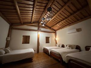 a room with three beds and a wooden ceiling at 芹壁小玖窩民宿 in Beigan