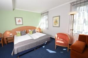 una camera d'albergo con letto e sedia di Hotel Anna Amalia a Weimar