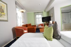 a hotel room with a bed and a living room at Hotel Anna Amalia in Weimar