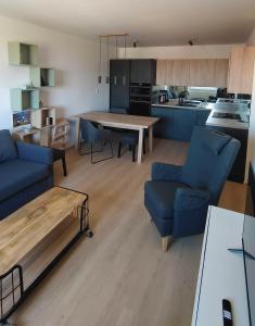 a kitchen and living room with a table and chairs at Stellaria apartment in Poprad