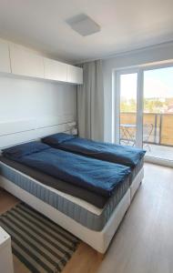 a large bed in a bedroom with a balcony at Stellaria apartment in Poprad