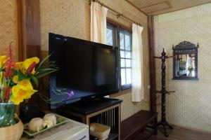 a flat screen tv sitting on a stand in a room at Farmstay at Pai in Pai