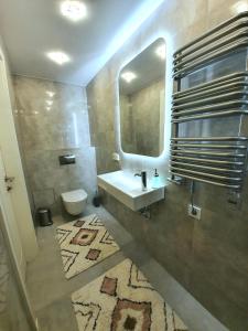 a bathroom with a sink and a mirror and a toilet at The Most Central Apartment in Kaunas