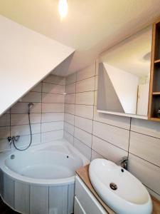 La salle de bains est pourvue d'une baignoire blanche et d'un lavabo. dans l'établissement Tourist Farm Pr' Maretč, à Bohinjska Bistrica