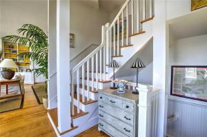 a white staircase with a dresser in a living room at Nash Cottage home in Atlantic Beach