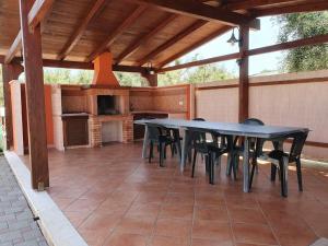 een patio met een tafel en stoelen en een open haard bij Country House in San Vito dei Normanni