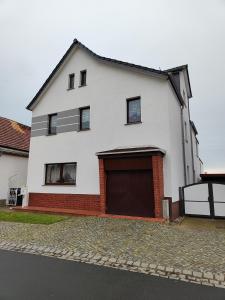 a white house with a brown garage at Pension Remenar & Lorenz in Zeithain