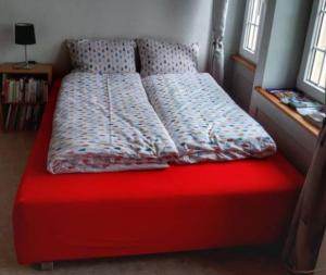 a bed with a red bed frame in a room at L'Annexe in Môtiers +16 photos