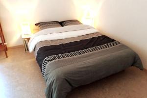 uma cama grande num quarto com duas lâmpadas em L'Annexe em Môtiers