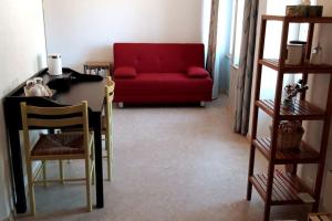 ein Wohnzimmer mit einem roten Sofa und einem Tisch in der Unterkunft L'Annexe in Môtiers
