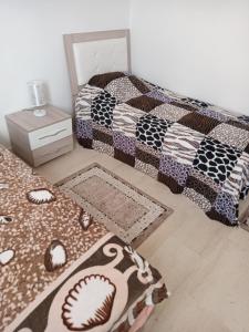 1 dormitorio con 1 cama con manta de béisbol y alfombras en Nour plage, en Sousse
