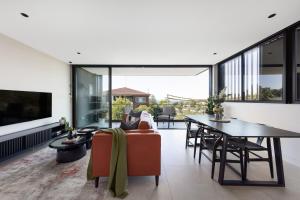 The Horizon Apartments by Urban Rest في سيدني: غرفة معيشة مفتوحة مع طاولة وأريكة